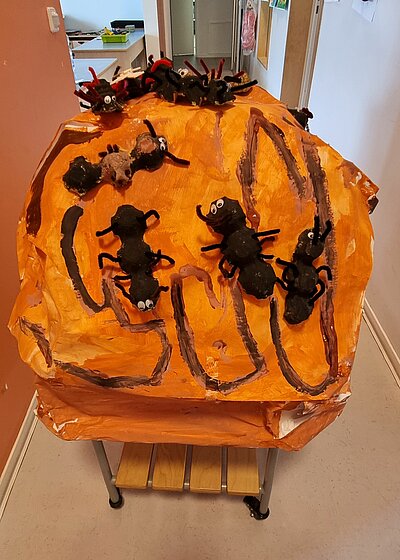 Ein aus Pappmache gebasteltes Modell eines Ameisenhügels auf einem Tisch mit Rollen.